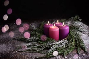 istockphoto-1356031406-612x612 Christmas eve, wreath with four burning purple advent candles on a dark wooden snowy background with festive bokeh lights.